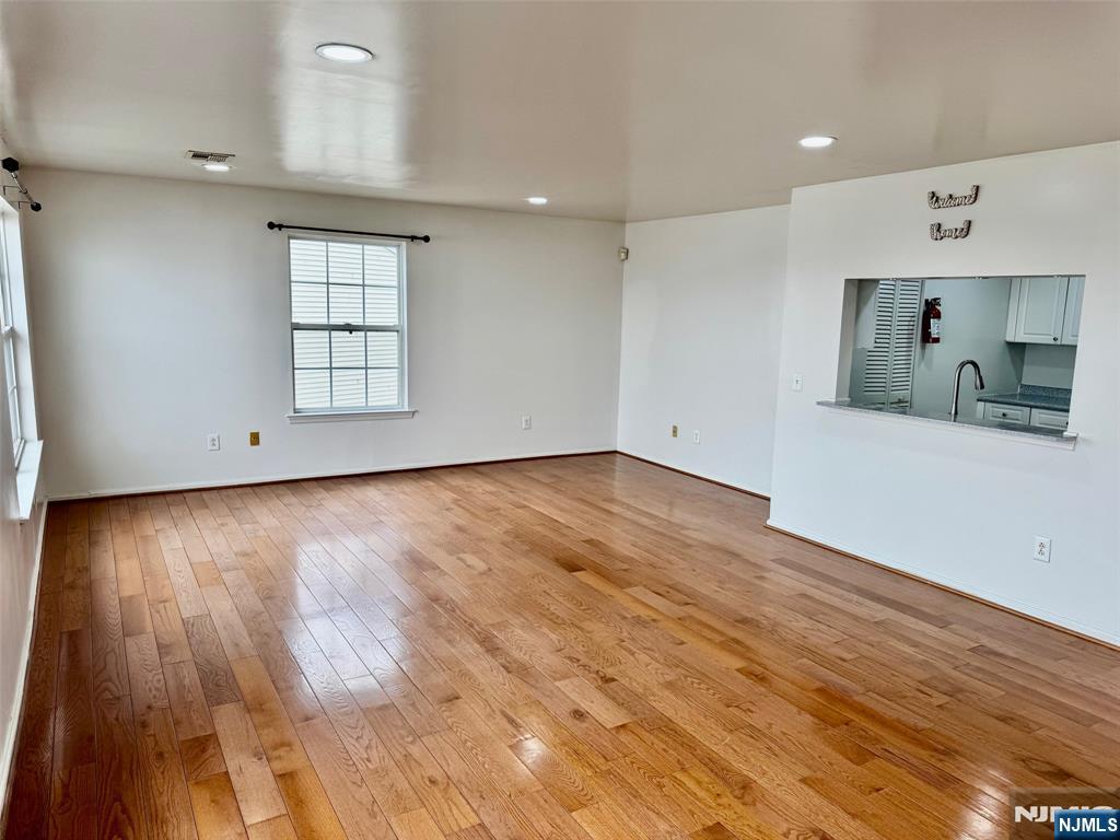 34 Bergen Ridge Road, Unit 2 North Bergen, NJ 07047 - Photo 5 of 41 an empty room with wooden floor and windows