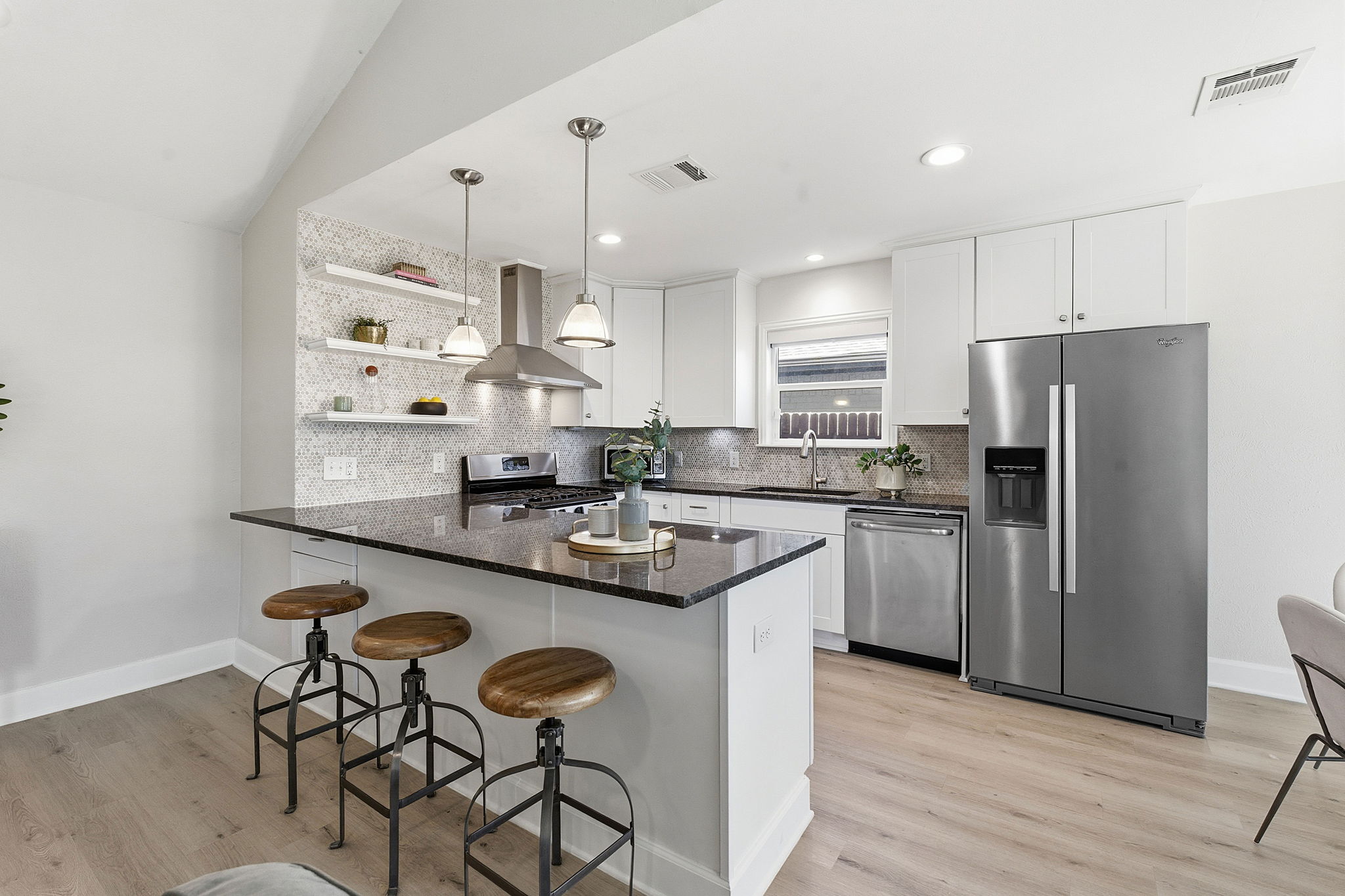 7105 Windrift Way Austin, TX 78745 - Photo 11 of 32 a kitchen with stainless steel appliances granite countertop a sink a stove a refrigerator and island with wooden floor