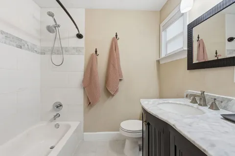 a bathroom with a granite countertop sink a toilet and shower