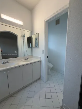 a bathroom with a sink a toilet and mirror