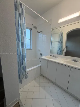 a bathroom with a bathtub sink and mirror