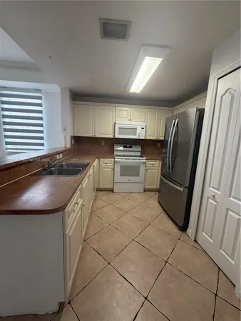 a kitchen with granite countertop a refrigerator sink and stove
