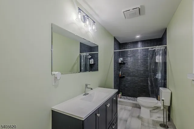 a kitchen with stainless steel appliances a sink a stove a refrigerator cabinets and a dining table