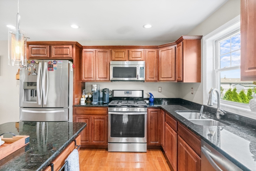 38 Renaud Street Fall River, MA 02721 - Photo 9 of 25 a kitchen with stainless steel appliances granite countertop a stove a sink and a refrigerator