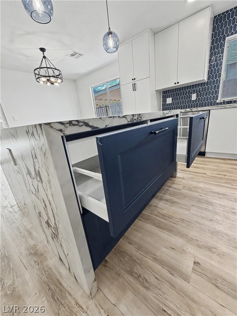 8977 Paige Rene Court Las Vegas, NV 89117 - Photo 12 of 31 A well-appointed kitchen showcasing a spacious island with ample storage and modern lighting fixtures.