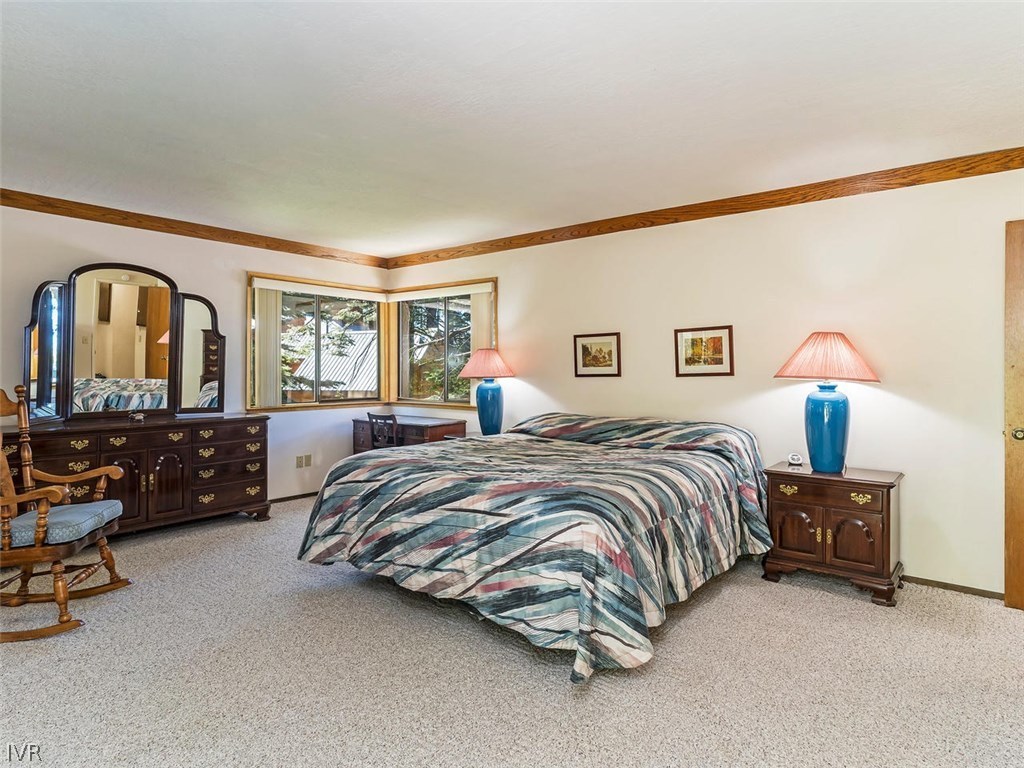1004 Apollo Way Incline Village, NV 89451 - Photo 11 of 21 a spacious bedroom with a bed a lamp and a large window