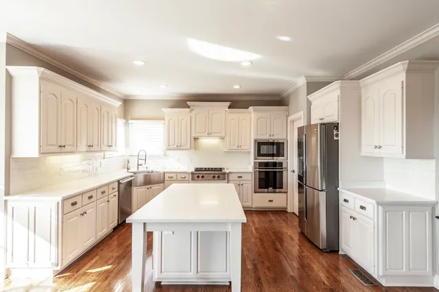 a view of a yard with flower plants and wooden fence