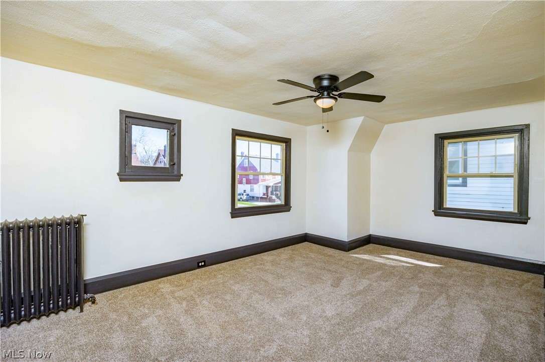 3254 Redwood Road Cleveland Heights, OH 44118 - Photo 33 of 49 Spare room featuring carpet floors, ceiling fan, and radiator heating unit