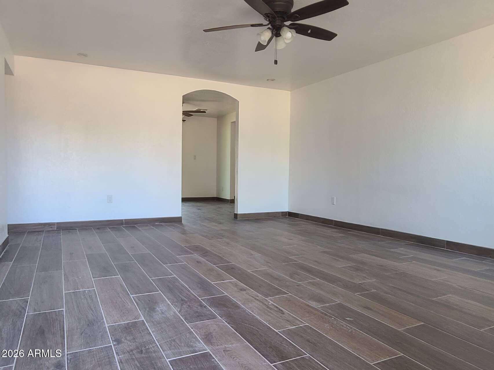 3702 East Thunderbird Road Phoenix, AZ 85032 - Photo 4 of 23 a view of a room with a wooden floor and a ceiling fan