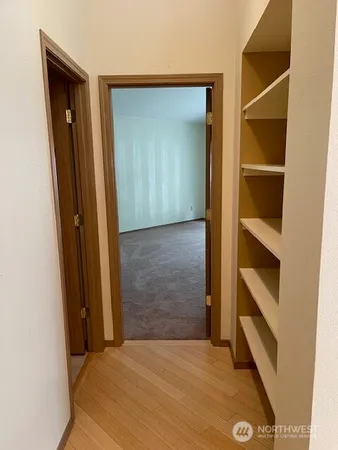 a view of an empty room with closet and wooden floor
