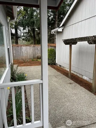 a view of backyard with table and chairs and wooden fence