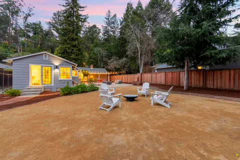 a view of a backyard with table and chairs with wooden fence