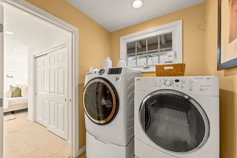front view of house with a yard and large trees
