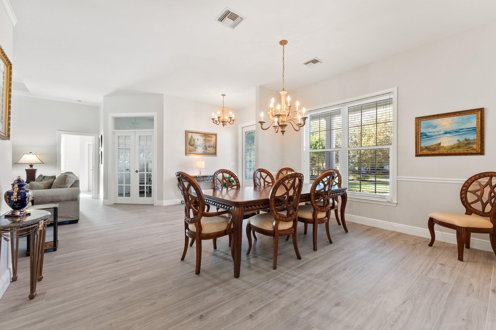 1680 Southeast Cypress Glen Way Stuart, FL 34997 - Photo 18 of 76 a view of a dining room with furniture window and wooden floor