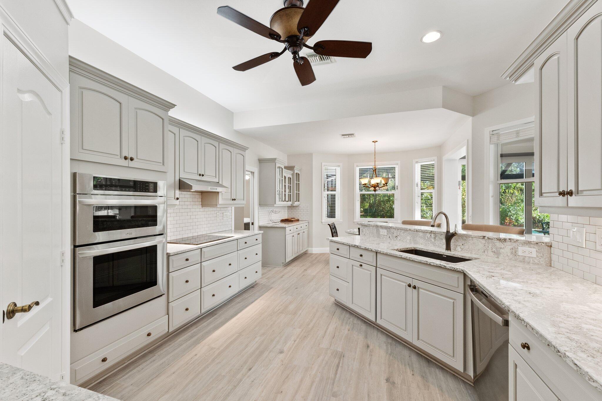 1680 Southeast Cypress Glen Way Stuart, FL 34997 - Photo 20 of 76 a kitchen with granite countertop a sink cabinets stainless steel appliances and a counter space