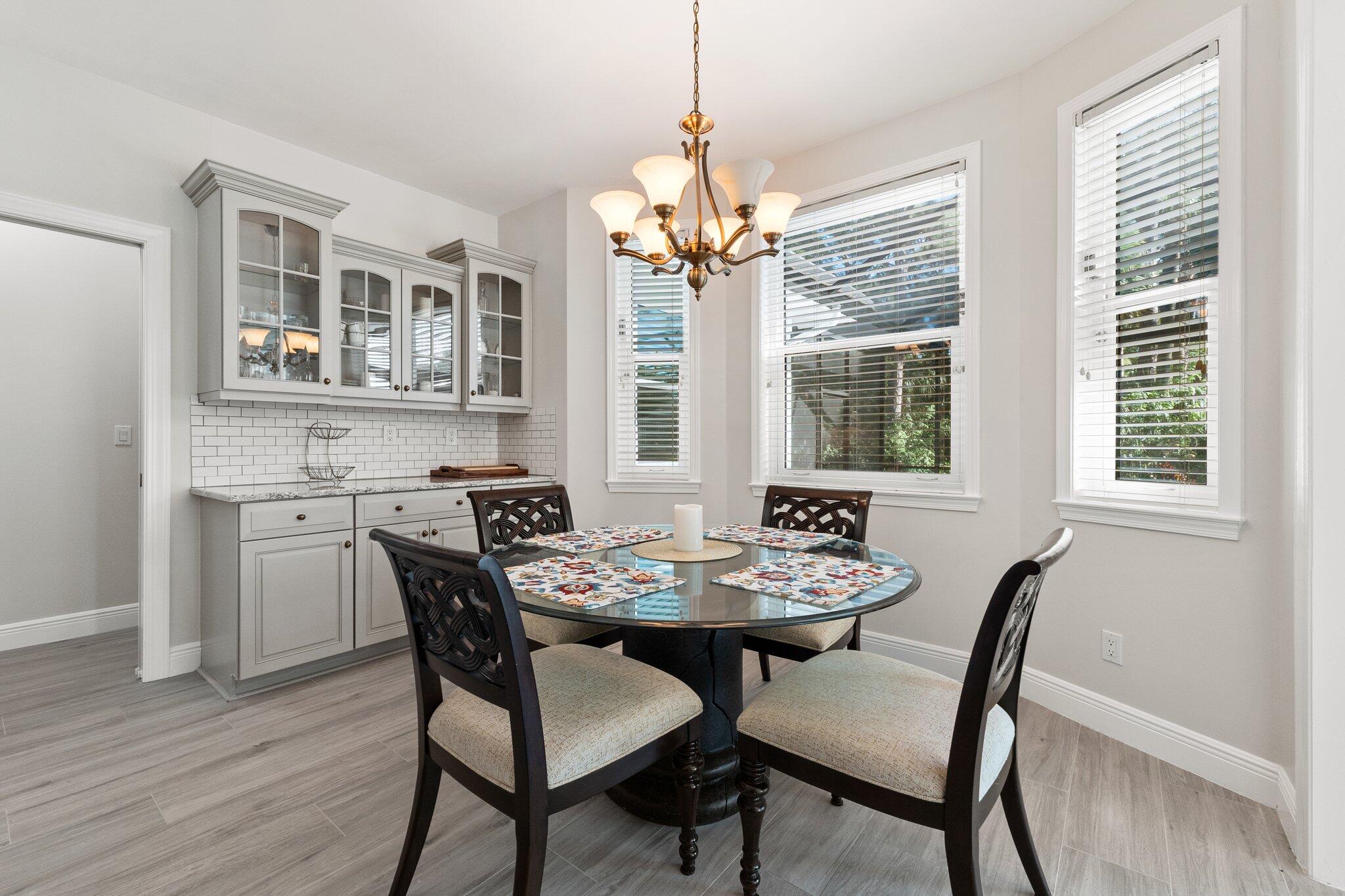 1680 Southeast Cypress Glen Way Stuart, FL 34997 - Photo 25 of 76 a dining room with furniture a chandelier and wooden floor