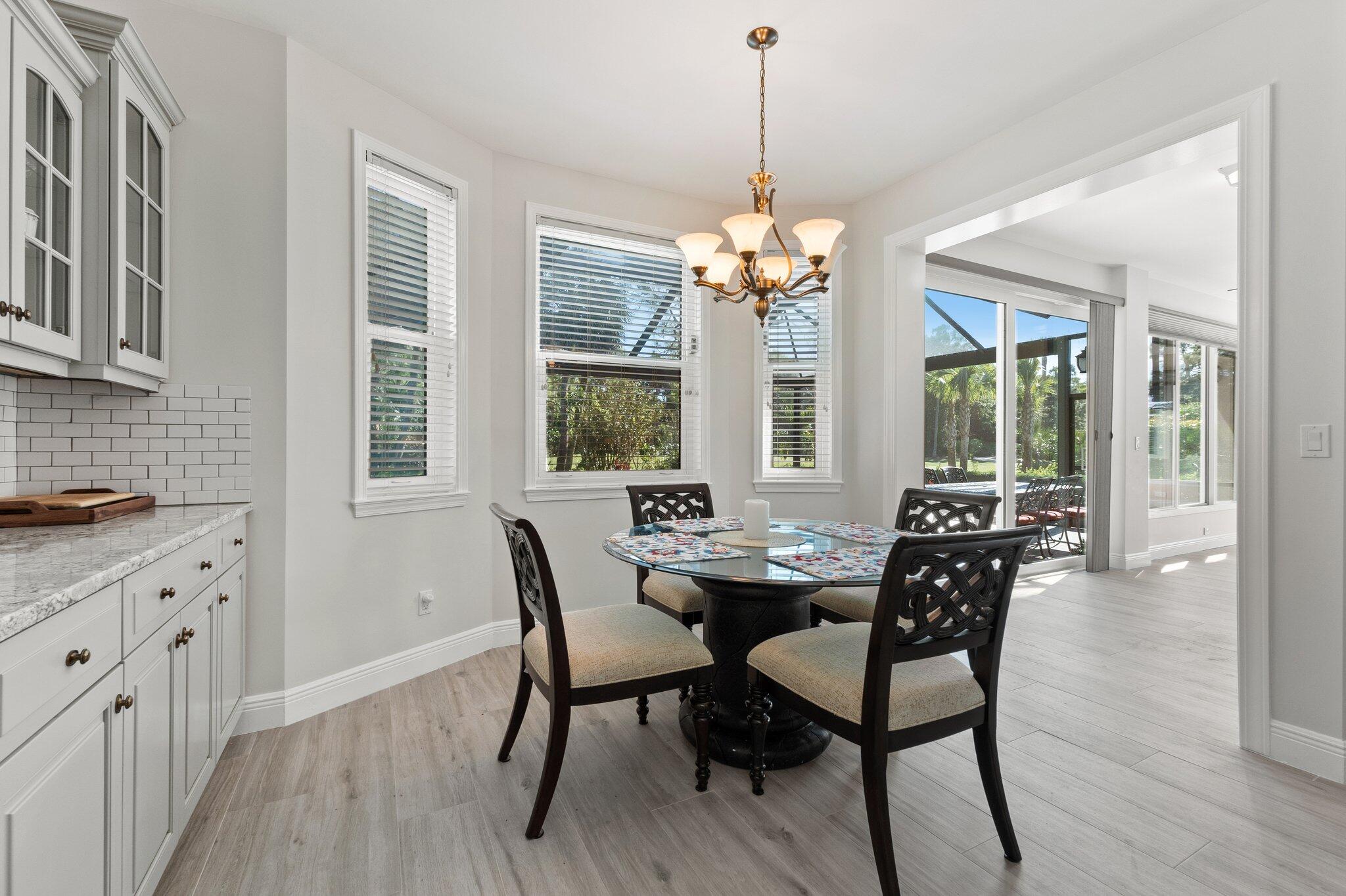 1680 Southeast Cypress Glen Way Stuart, FL 34997 - Photo 26 of 76 a view of a dining room with furniture wooden floor and chandelier