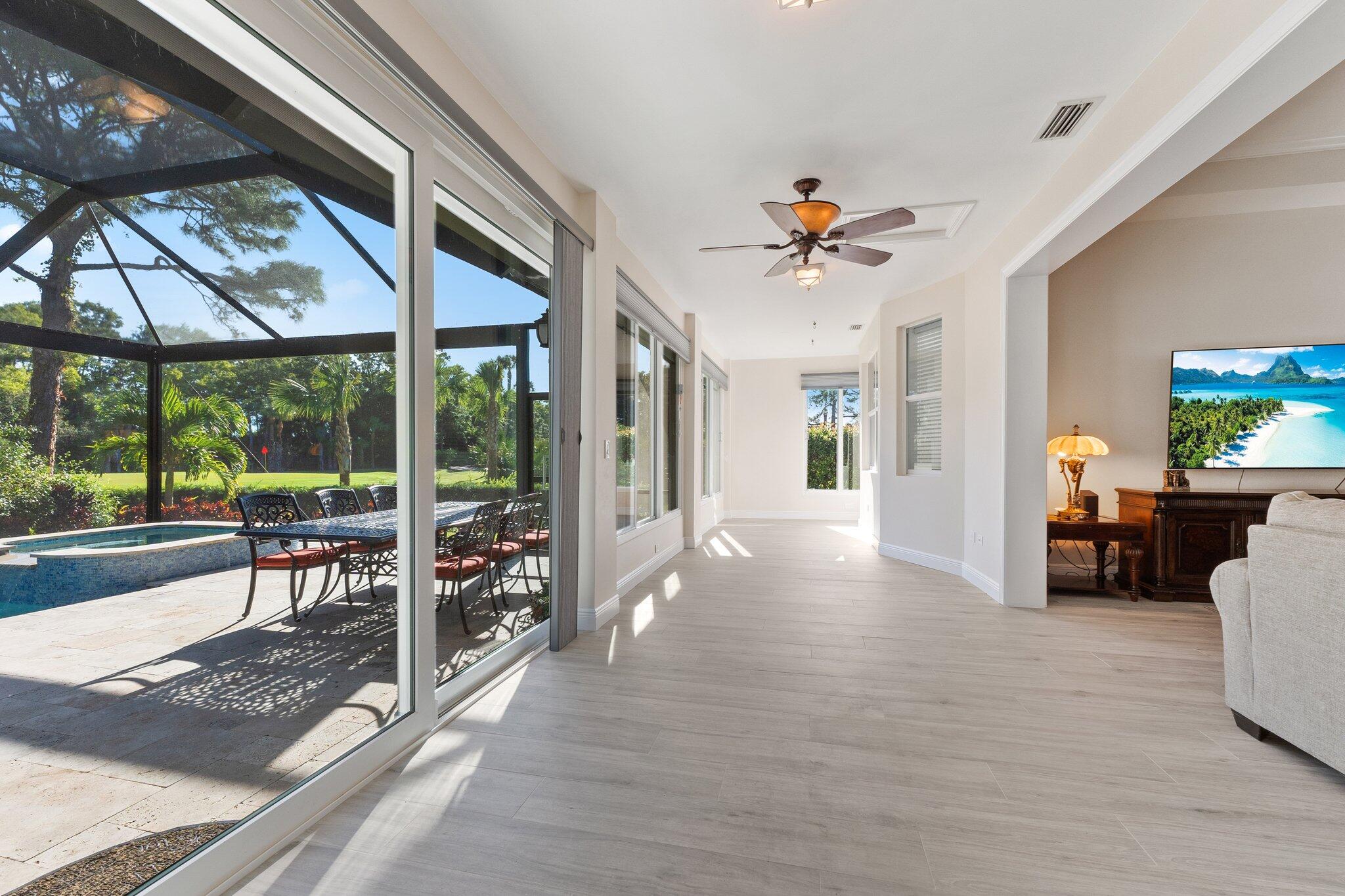 1680 Southeast Cypress Glen Way Stuart, FL 34997 - Photo 27 of 76 a view of a livingroom with furniture wooden floor and a floor to ceiling window