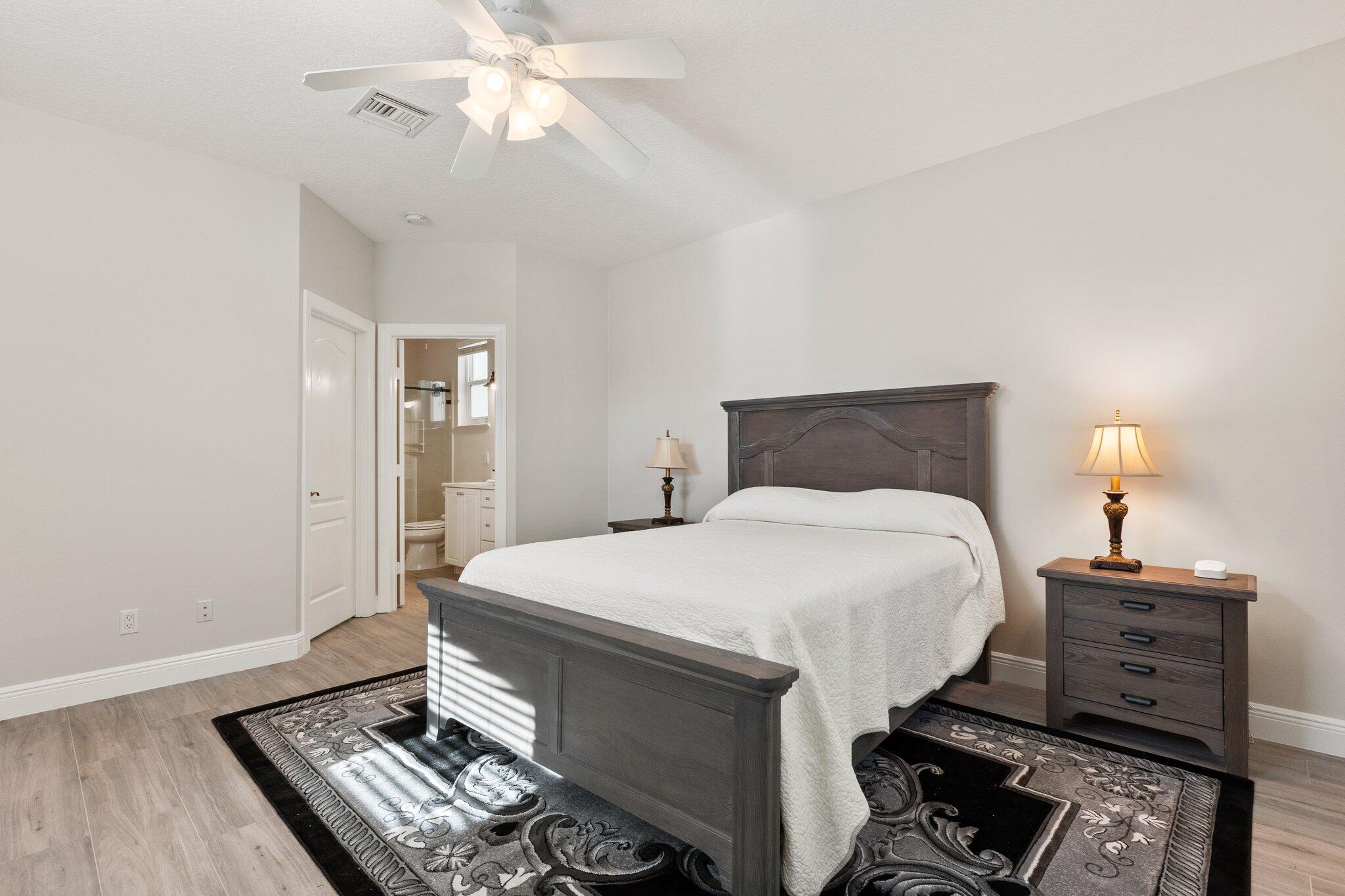 1680 Southeast Cypress Glen Way Stuart, FL 34997 - Photo 35 of 76 a bedroom with a bed and a chandelier