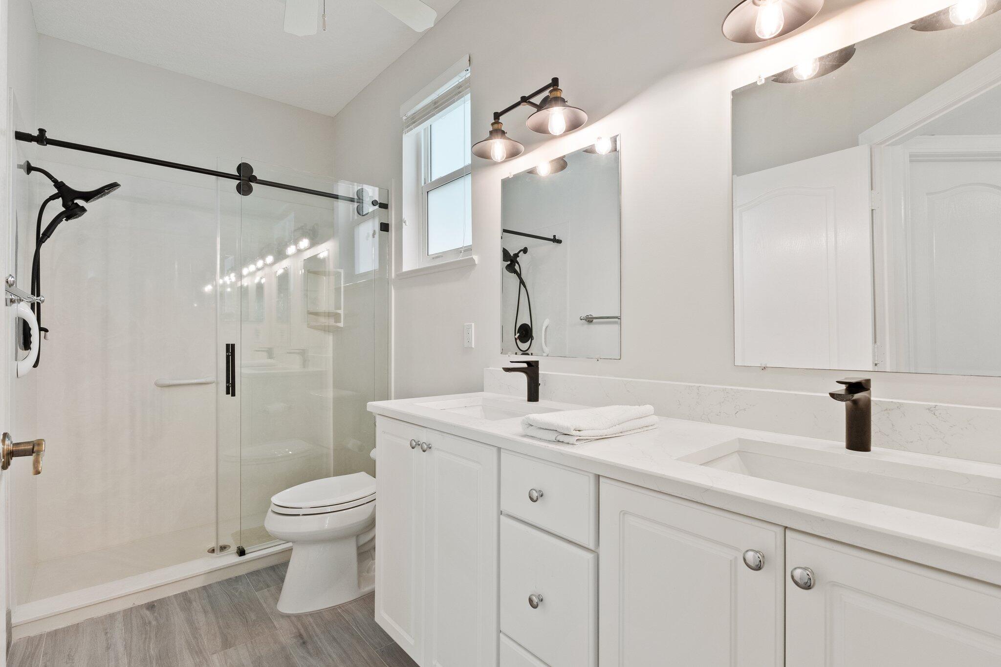 1680 Southeast Cypress Glen Way Stuart, FL 34997 - Photo 36 of 76 a bathroom with a sink a toilet and shower