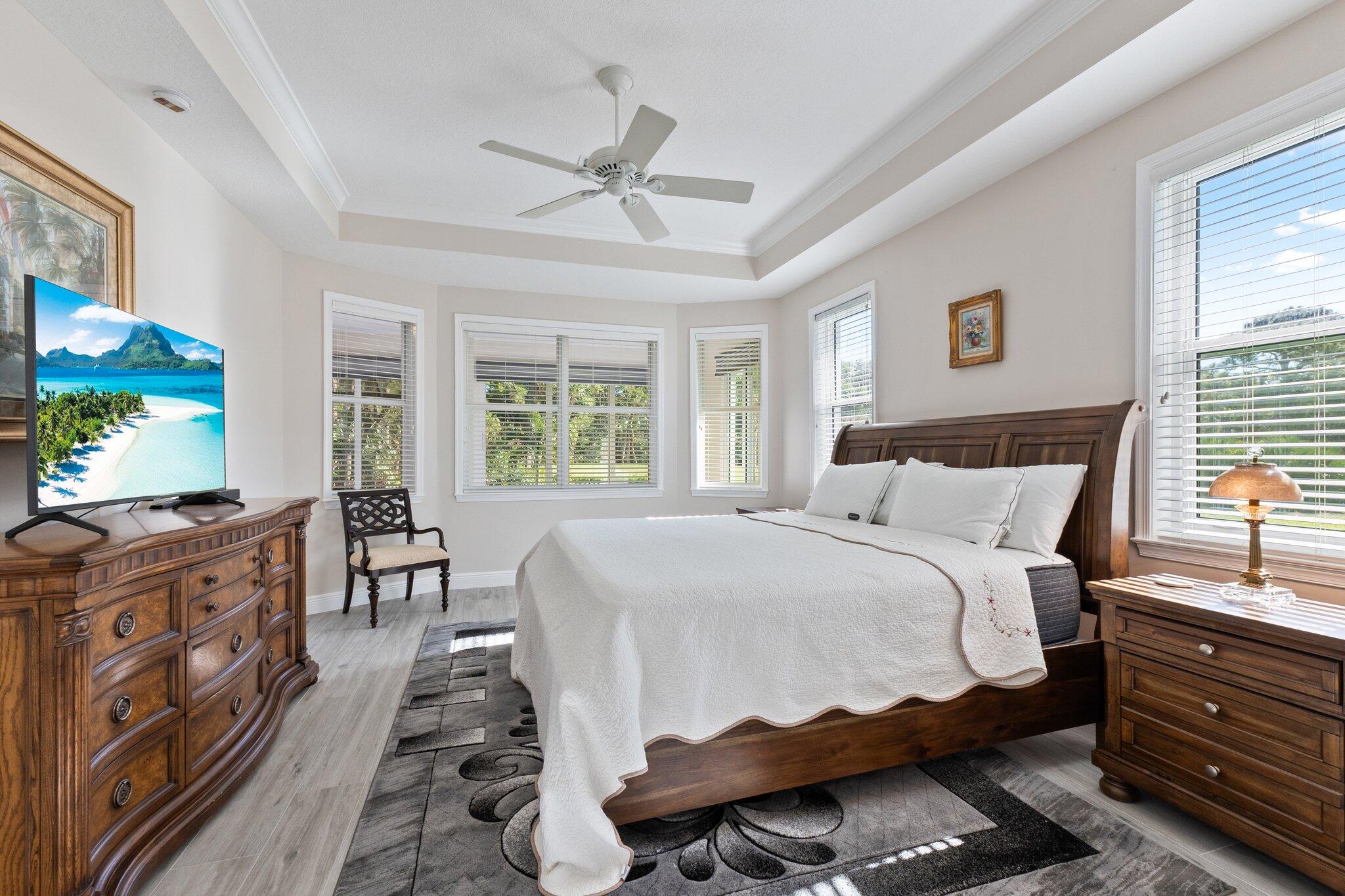 1680 Southeast Cypress Glen Way Stuart, FL 34997 - Photo 40 of 76 a bedroom with a bed and a dresser next to a window