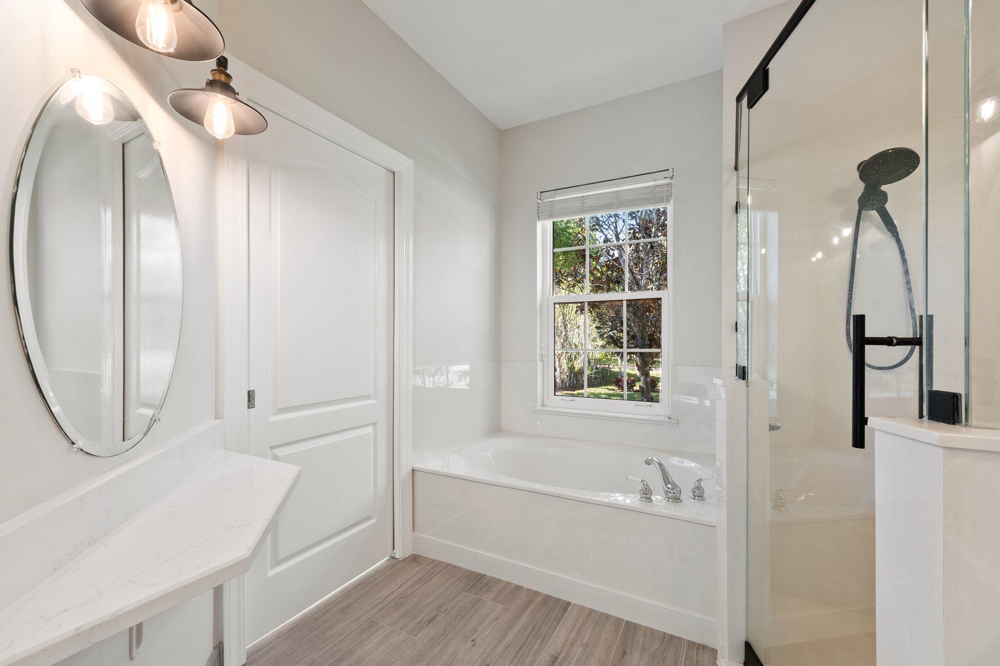 1680 Southeast Cypress Glen Way Stuart, FL 34997 - Photo 45 of 76 a bathroom with a tub sink and a mirror