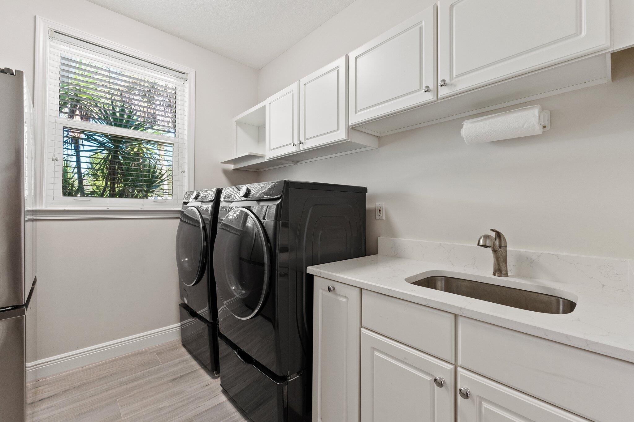 1680 Southeast Cypress Glen Way Stuart, FL 34997 - Photo 49 of 76 a utility room with cabinets