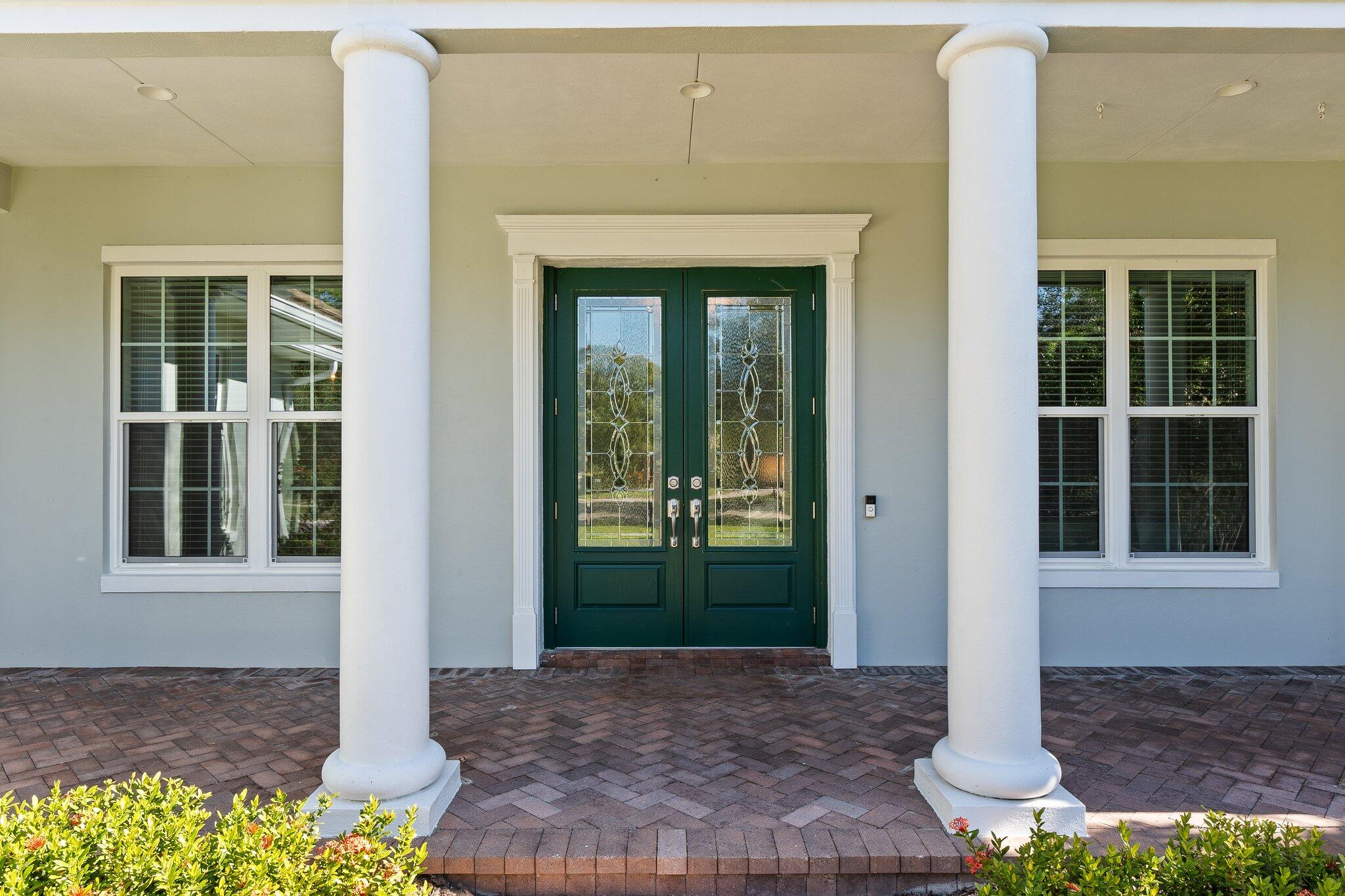 1680 Southeast Cypress Glen Way Stuart, FL 34997 - Photo 61 of 76 a front view of a house with a porch