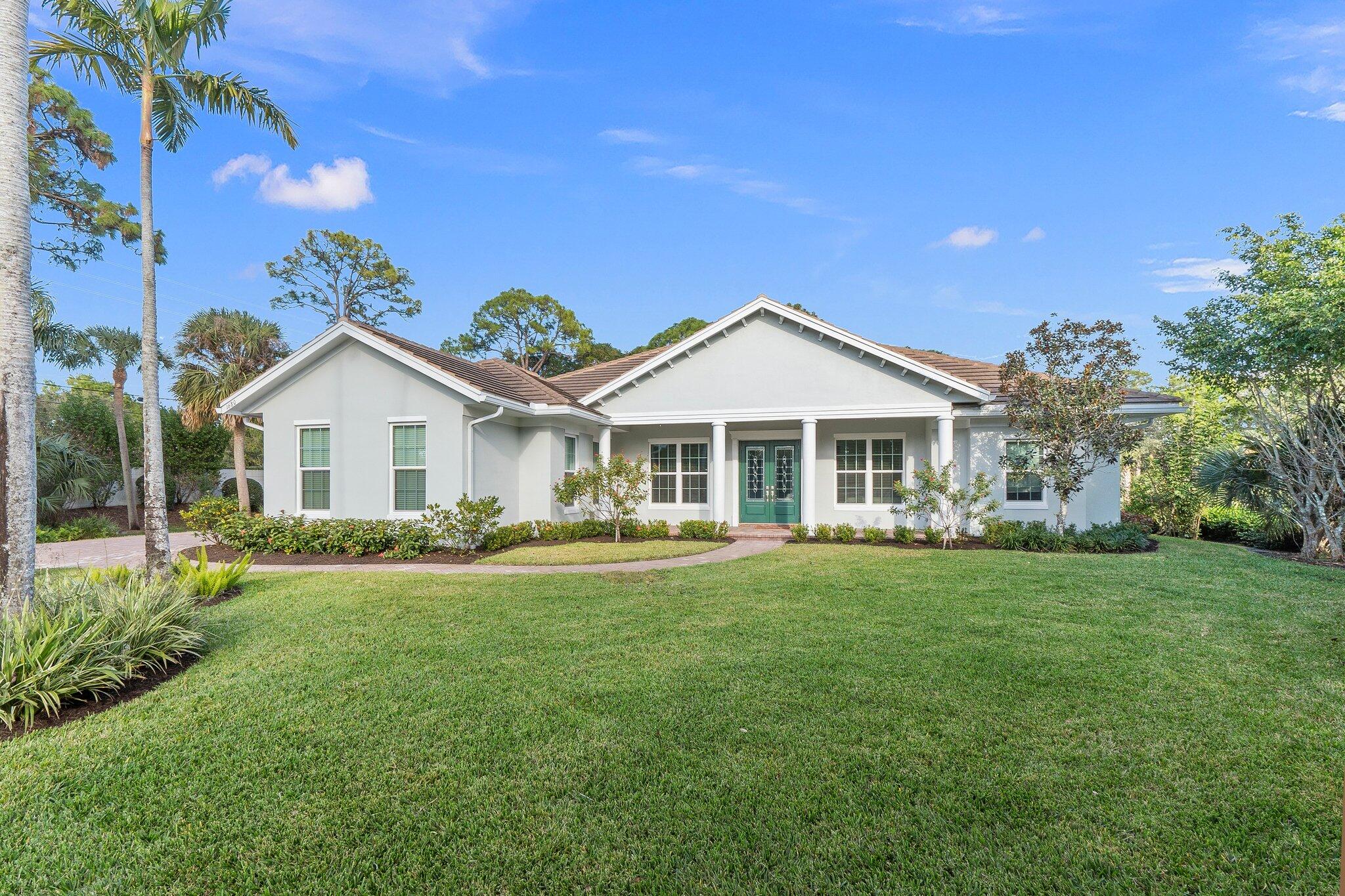 1680 Southeast Cypress Glen Way Stuart, FL 34997 - Photo 7 of 76 a front view of a house with a yard and porch