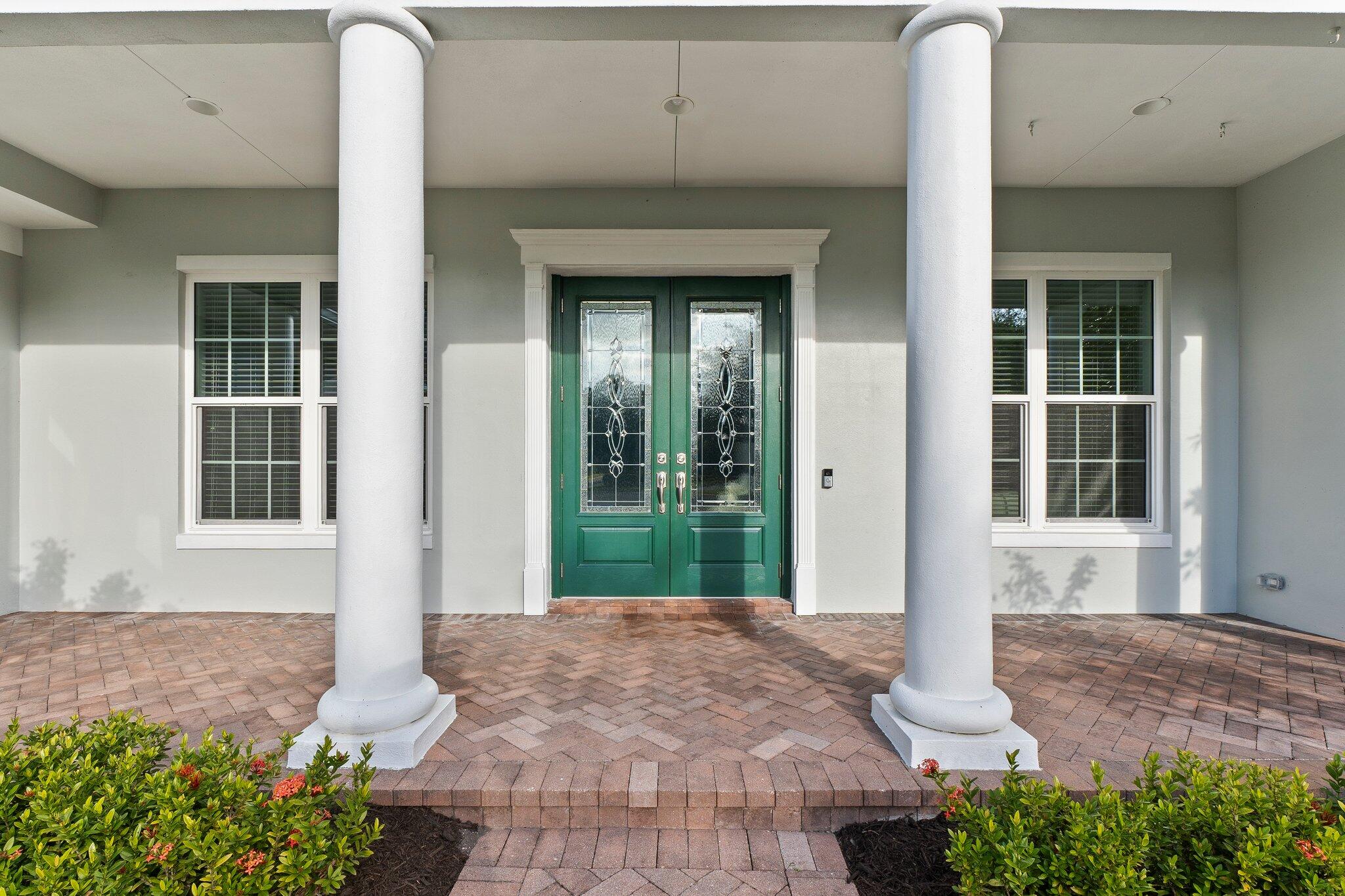 1680 Southeast Cypress Glen Way Stuart, FL 34997 - Photo 9 of 76 a front view of a house with a yard