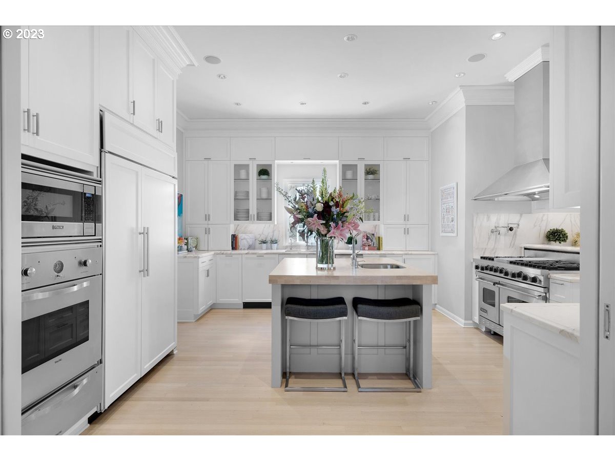 554 Southwest 48th Drive Portland, OR 97221 - Photo 11 of 48 a kitchen with stainless steel appliances kitchen island granite countertop a sink stove and refrigerator