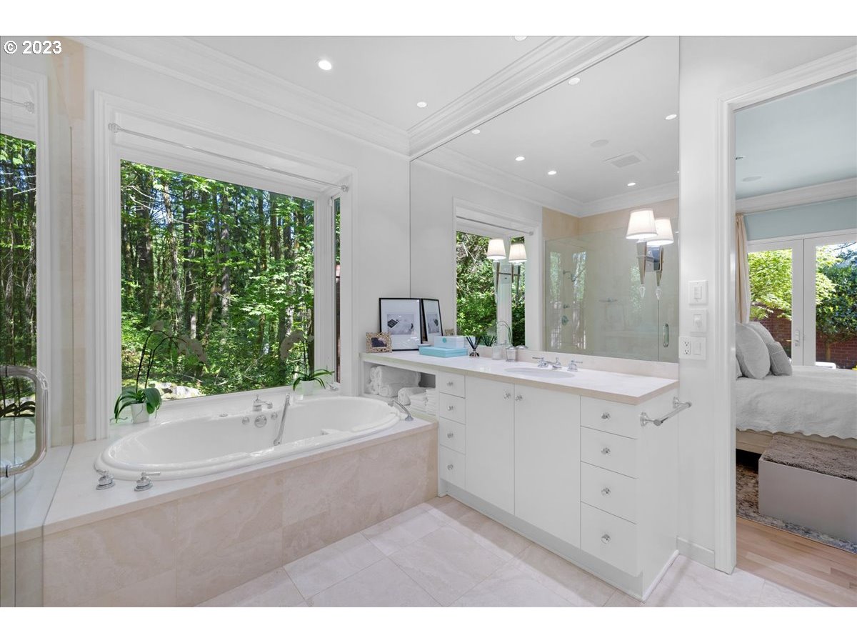 554 Southwest 48th Drive Portland, OR 97221 - Photo 26 of 48 a bathroom with a bathtub a sink a large mirror and a bathtub