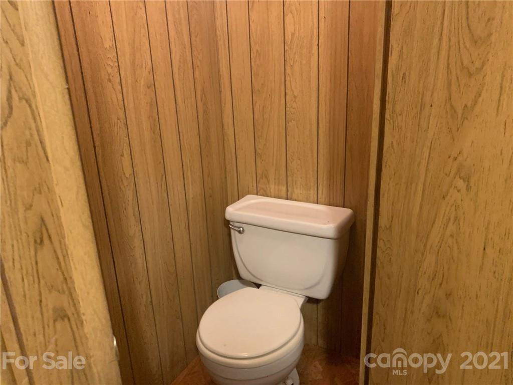 887 Meadowbrook Road, Unit 3 Chester, SC 29706 - Photo 10 of 15 a white toilet sitting next to a wooden cabinet