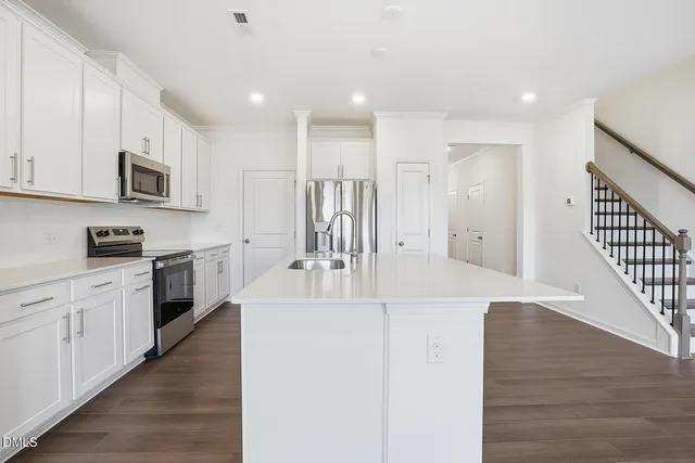 a large white kitchen with stainless steel appliances