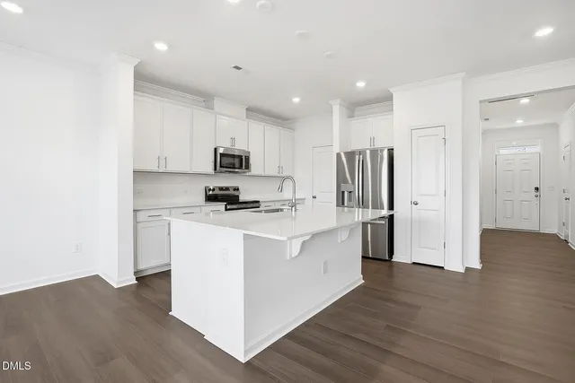 a kitchen with stainless steel appliances a refrigerator and a stove top oven