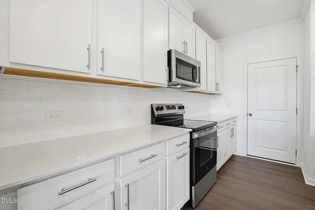 a kitchen with white cabinets and appliances