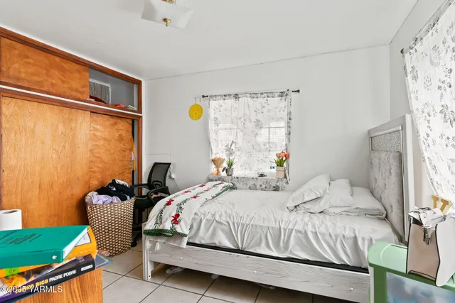 a bedroom with a bed chair and window