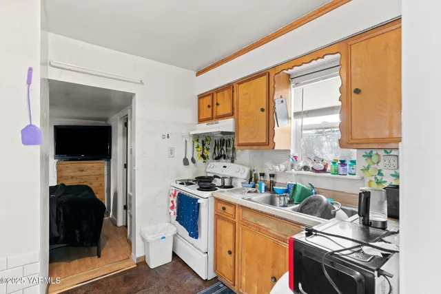 a kitchen with a sink appliances cabinets and a counter top space