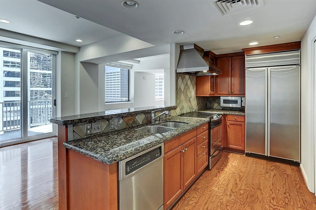 914 Main Street, Unit 1806 Houston, TX 77002 - Photo 2 of 21 a kitchen with granite countertop a sink and a refrigerator