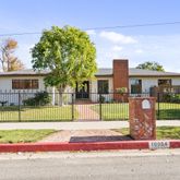 a front view of a house with a garden and plants