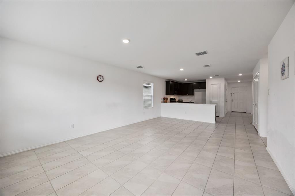 6038 Determine Lane Forney, TX 75126 - Photo 14 of 26 Open-concept living space featuring light-toned tile flooring, recessed lighting, and a kitchen area with dark cabinetry and a breakfast bar