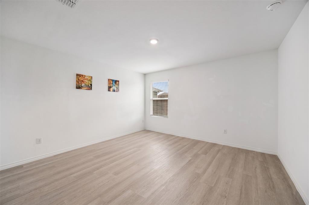 6038 Determine Lane Forney, TX 75126 - Photo 16 of 26 Spacious room featuring light wood-finish flooring, crisp white walls, and a recessed ceiling light