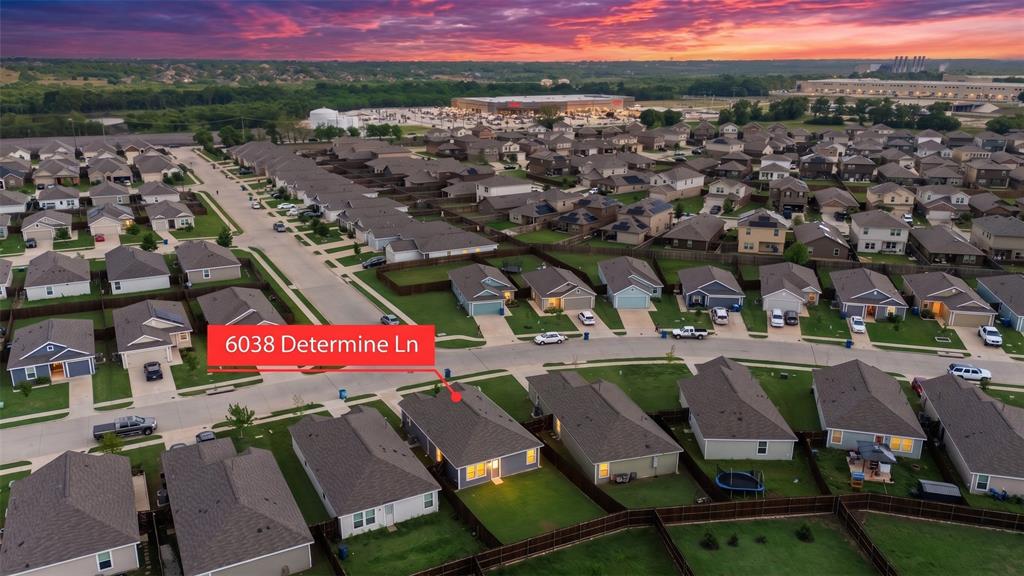 6038 Determine Lane Forney, TX 75126 - Photo 25 of 26 Aerial perspective of a residential neighborhood with single-story homes, featuring uniform rooflines and individual fenced backyards