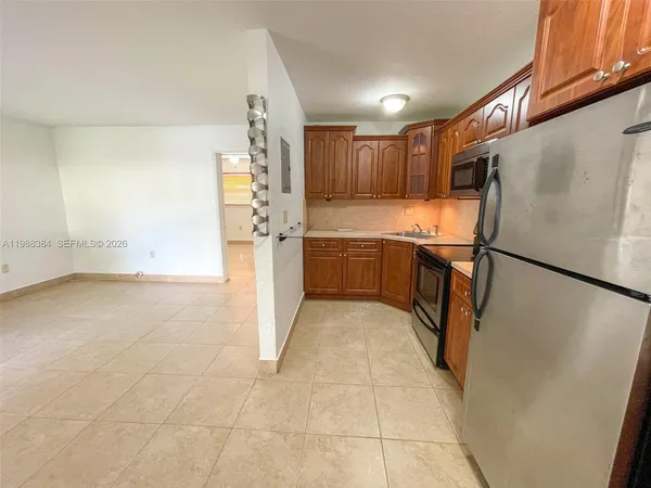 a kitchen with granite countertop a refrigerator a sink and dishwasher