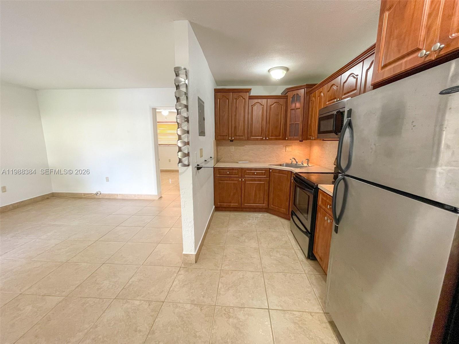 4450 Southwest 67th Avenue, Unit I Miami, FL 33155 - Photo 5 of 12 a kitchen with granite countertop a refrigerator a sink and dishwasher