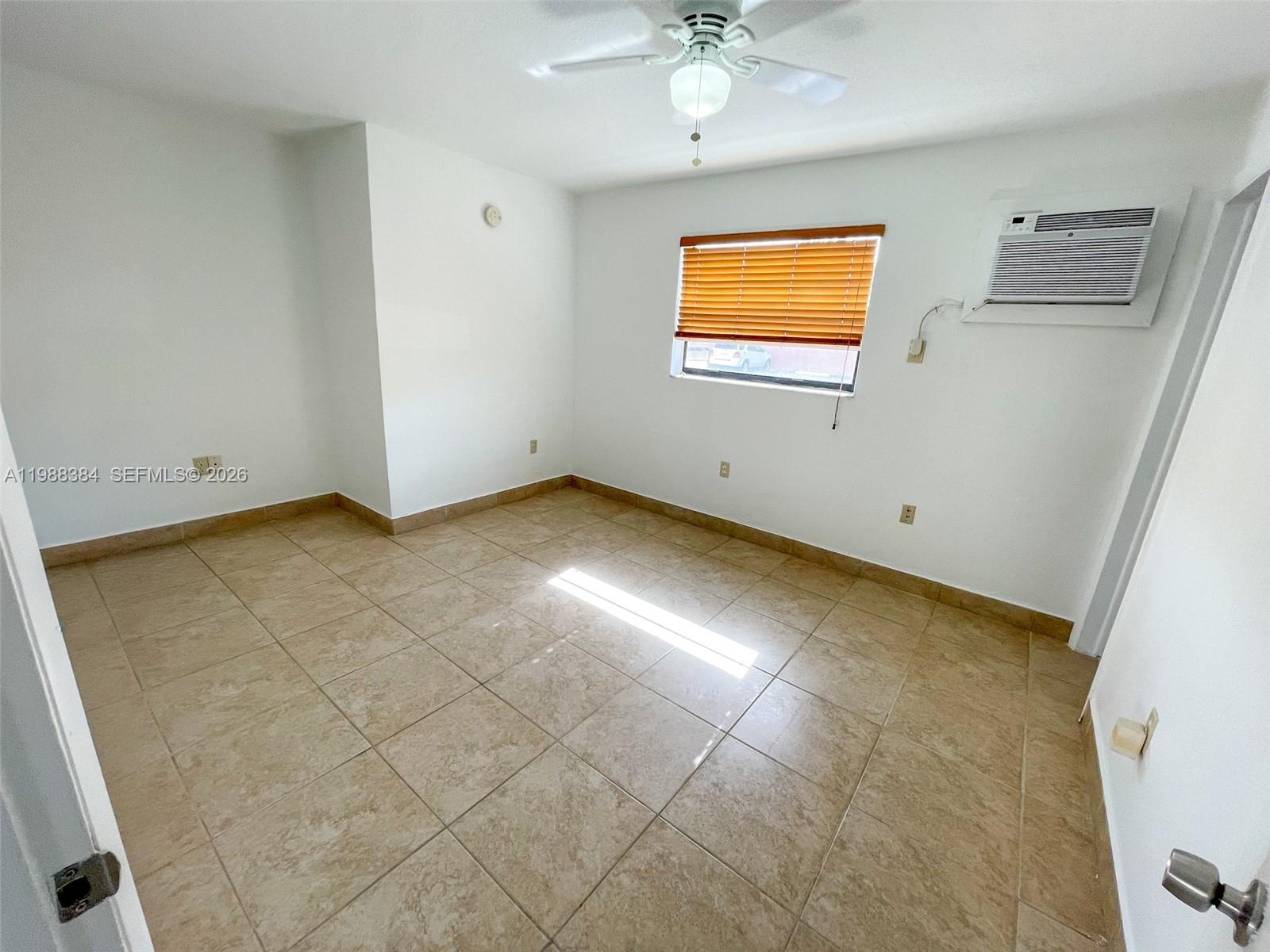 4450 Southwest 67th Avenue, Unit I Miami, FL 33155 - Photo 8 of 12 an empty room with windows and fan