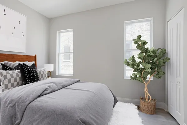 a bedroom with a bed and a potted plant
