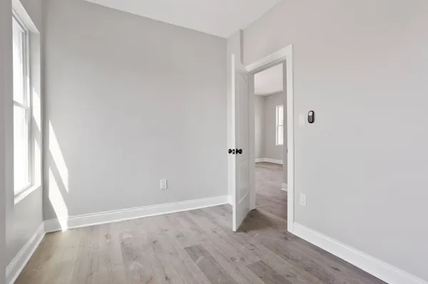 an empty room with wooden floor and a window