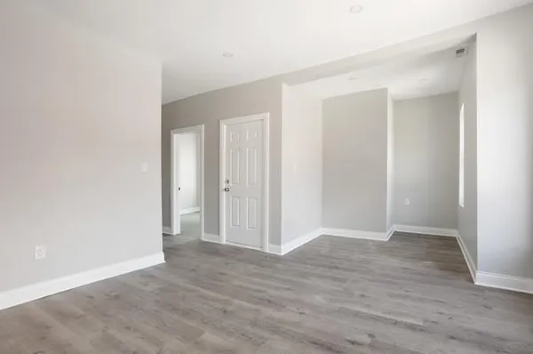 a view of an empty room with wooden floor