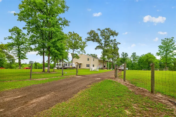 a green field with lots of trees in the background